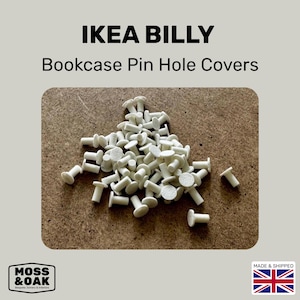 May include: A pile of white IKEA BILLY bookcase pin hole covers. The covers are small, with a round head and a cylindrical stem. The text "IKEA BILLY Bookcase Pin Hole Covers" is at the top of the image.