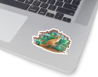 May include: A sticker featuring a stylized illustration of a kangaroo with a joey, nestled among lush green and blue foliage. The kangaroo is depicted in shades of tan and brown, with long ears and a relaxed posture. The sticker has a white border.