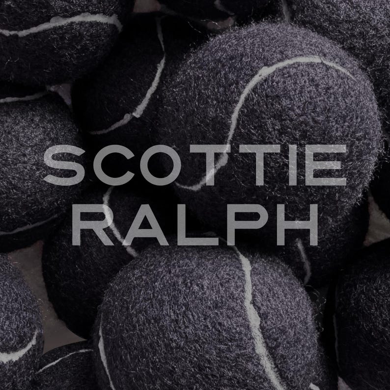 May include: A collection of dark grey tennis balls with a fuzzy texture and white curved seams. The text SCOTTIE RALPH is overlaid in a light grey sans-serif font across the centre of the image, partially obscuring the tennis balls.