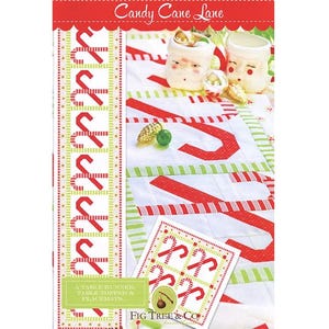 May include: A festive Christmas-themed fabric pattern with the text "Candy Cane Lane." The design features red and white candy canes, green accents, and a small card with a candy cane pattern. The image also includes two Santa mugs.