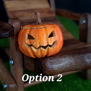 May include: A small orange jack-o'-lantern with a carved, jagged face and a brown stem. The pumpkin features deep vertical ridges and a glossy finish. The text 'Option 2' is printed in white in the lower portion of the image.
