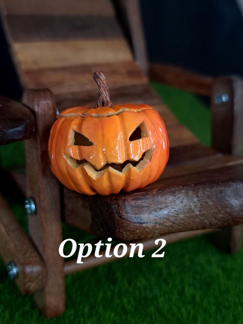 May include: A small orange jack-o'-lantern with a carved, jagged face and a brown stem. The pumpkin features deep vertical ridges and a glossy finish. The text 'Option 2' is printed in white in the lower portion of the image.