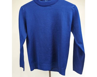 Könnte beinhalten: Ein langärmliger, königsblauer Pullover mit Stehkragen. Der Pullover ist aus feinem Strickstoff gefertigt und hängt an einem Holzbügel. Das Kleidungsstück hat ein klassisches, schlichtes Design.