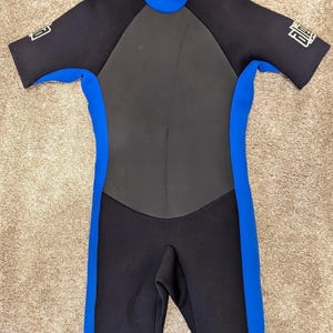 Könnte beinhalten: Schwarzer, kurzarmiger Neoprenanzug mit blauen Einfassungen und dem Wort "FIRE" am Arm.