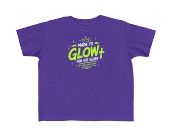 May include: A purple short-sleeve t-shirt featuring a lime green graphic print that reads MADE TO GLOW FOR HIS GLORY, LET YOUR LIGHT SHINE MATTHEW 5:16, accompanied by a crown icon and a cross symbol, centered on the chest of the garment.