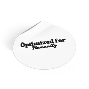 Peut inclure: Autocollant blanc découpé avec le texte "Optimized for Humanity" en gras, en noir. L'autocollant a une forme arrondie avec une légère courbe en haut, suggérant qu'il se détache d'une surface. Le design est simple et moderne.