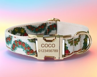 Puede incluir: Un collar de perro blanco con una hebilla dorada y una etiqueta de nombre personalizada que dice "COCO 0123456789". El collar tiene un patrón festivo de ramas de pino verdes, bayas rojas y estrellas doradas.