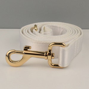 May include: White cotton dog leash with a gold metal clip.