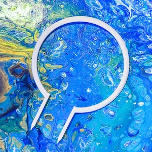 May include: A white circle frame with a pointed bottom, set against a blue and yellow abstract background. The background is reminiscent of a swirling, marbled paint effect.