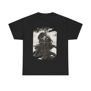 Könnte beinhalten: Schwarzes T-Shirt mit einem sepiafarbenen Bild einer Person auf einem Motorrad. Das Bild hat einen Vintage-Look mit dunklem Hintergrund und einem Grunge-Stil-Rand.