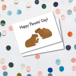 May include: A white card with the text "Happy Parents' Day!" features a brown capybara family illustration. The card is surrounded by colorful confetti in shades of blue, green, orange, and pink.