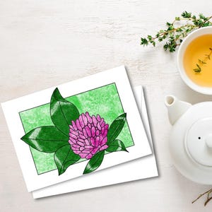 以下が含まれることがあります： ピンクのクローバーの花と緑の葉の水彩イラストが描かれた2枚の白いカード。イラストの背景は明るい緑色の正方形です。白いティーポットと、タイムの小枝が入ったお茶のカップも画像にあります。