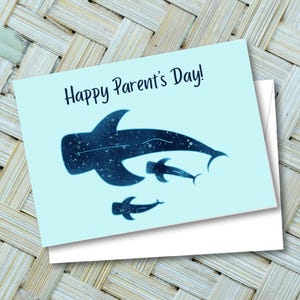 May include: A light blue greeting card with the text "Happy Parent's Day!" and a dark blue whale shark illustration. The card is paired with a white envelope, perfect for gifting.