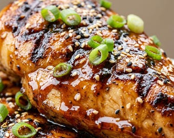 May include: A grilled chicken breast glazed in a dark, glossy sauce, topped with a generous sprinkling of white and black sesame seeds and freshly sliced green scallion rings, featuring visible dark char marks from the cooking process.