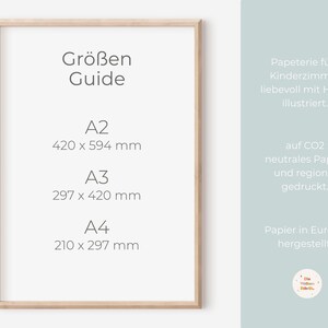 Może przedstawiać: Ramka z plakatem zawierającym tabelę rozmiar&oacute;w papieru A2, A3 i A4. Plakat jest w jasnej drewnianej ramie i ma białe tło. Tekst na plakacie jest w języku niemieckim i zawiera wymiary każdego rozmiaru papieru w milimetrach.