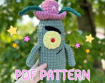 May include: Crochet pattern for a green Plankton plush toy from the cartoon Spongebob Squarepants. Plankton is wearing a pink cowboy hat with a white star. The pattern is available as a PDF download.