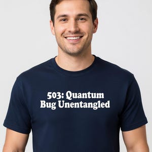 Może przedstawiać: Granatowa koszulka z białym napisem "503: Quantum Bug Unentangled". Koszulka ma okrągły dekolt i jest noszona przez osobę.