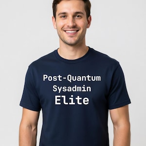Puede incluir: Camiseta azul marino con el texto blanco "Post-Quantum Sysadmin Elite". La camiseta es de cuello redondo y la lleva una persona. El fondo es gris claro liso.