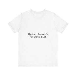以下が含まれることがあります： 白のTシャツに黒字で「Alpine: Docker's Favorite Diet」とプリントされています。クルーネックのベーシックなデザインで、カジュアルな着こなしに最適です。