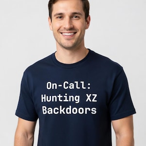 Puede incluir: Camiseta azul marino con el texto blanco "On-Call: Hunting XZ Backdoors". La camiseta está hecha de un material suave y es adecuada para ropa casual. El texto está centrado en la parte delantera.