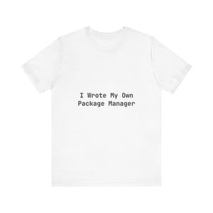 May include: White short-sleeve t-shirt with the text "I Wrote My Own Package Manager" in black, centered on the front. The shirt is made of a soft, lightweight fabric.