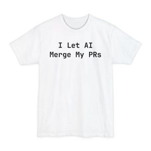 Puede incluir: Camiseta blanca con el texto negro "I Let AI Merge My PRs" centrado en la parte delantera. La camiseta tiene cuello redondo y mangas cortas. La tela parece ser una mezcla de algodón suave.