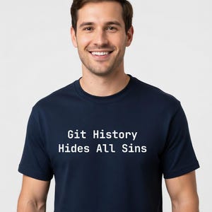 Puede incluir: Una camiseta azul marino con el texto blanco "Git History Hides All Sins". La camiseta la lleva una persona con cabello castaño y una sonrisa.