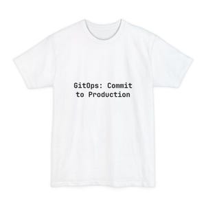 May include: White t-shirt featuring the text "GitOps: Commit to Production" in black. The shirt has a round neck and short sleeves. The text is centrally placed on the front of the garment.
