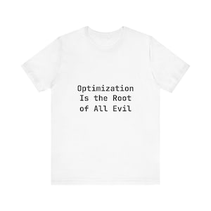 Può includere: T-shirt bianca con la scritta nera "Optimization Is the Root of All Evil" centrata. La maglietta ha maniche corte e girocollo, adatta per un look casual.