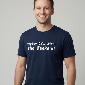 May include: A navy blue short-sleeved t-shirt featuring the white text "Deploy Only After the Weekend" printed across the chest. The garment has a classic crew neckline and a standard fit, constructed from a solid-coloured fabric.