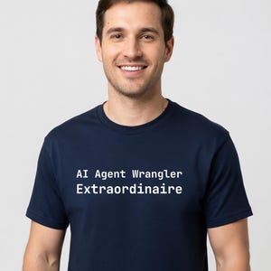 May include: Navy blue t-shirt with the text "AI Agent Wrangler Extraordinaire" in white. The shirt is a crew neck style and is being worn by a person.