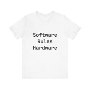 Könnte beinhalten: Weißes T-Shirt mit dem schwarzen Text "Software Rules Hardware" mittig auf der Vorderseite. Das T-Shirt hat kurze Ärmel und einen Rundhalsausschnitt.