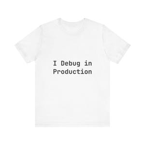 Puede incluir: Camiseta blanca con el texto negro "I Debug in Production". La camiseta de manga corta tiene cuello redondo y es adecuada para el uso diario. El texto está centrado en la parte delantera de la camiseta.
