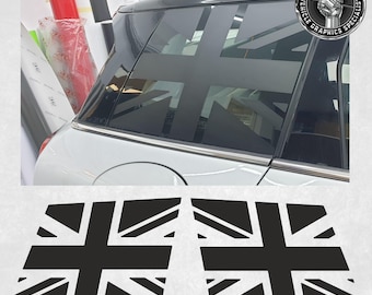 Op de afbeelding: Twee zwarte en witte Union Jack-stickers voor autovensters. De stickers zijn ontworpen om te worden aangebracht op de achterste zijruiten van een auto. De stickers zijn gemaakt van hoogwaardig vinyl en zijn waterdicht en UV-bestendig.