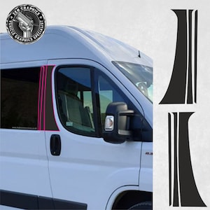 Op de afbeelding: Een witte bestelwagen met zwarte raambekleding en een zwarte en roze streepsticker aan de zijkant. De sticker is een set van twee verticale strepen met een gebogen bovenkant.