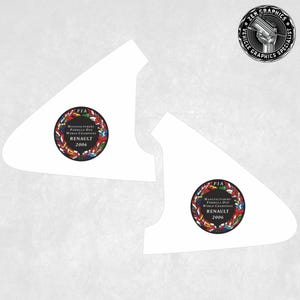 Könnte beinhalten: Zwei weiße dreieckige Autofensteraufkleber mit einem schwarzen Kreis in der Mitte. Der Kreis ist von einem Kranz aus Flaggen umgeben und dem Text "FIA Hersteller Formel 1 Weltmeister Renault 2006".
