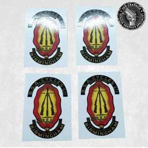 May include: Four vintage B.S.A. Cycles stickers with a red, yellow, and black design. The stickers feature three rifles with the text "B.S.A. Cycles Proprietors Ltd. The Birmingham Small Arms Co. Birmingham" in a black oval.