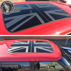 May include: A red car with a sunroof featuring a black and grey Union Jack flag decal. The decal is applied to the glass of the sunroof.