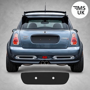 Puede incluir: Vista trasera de un Mini Cooper S Works GP azul con un alerón de techo prominente, tubos de escape centrales dobles y luces traseras rojas. El maletero muestra los emblemas Works GP y Cooper S. Se muestra un panel de relleno negro para la matrícula.