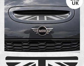 May include: A black and white Union Jack flag decal designed for a Mini Cooper hood scoop. The decal features a stylized British flag pattern with bold lines and geometric shapes, shown applied to a dark gray vehicle hood with a Mini emblem.