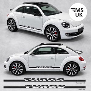 以下が含まれることがあります： TURBOの文字が入った黒いサイドデカールを施した白いフォルクスワーゲン・ビートル。車両には黒いルーフ、黒いサイドミラー、マルチスポークホイールが装備されています。車の下には、TURBOの文字が入った2つの独立した黒いサイドストライプデカールが表示されています。