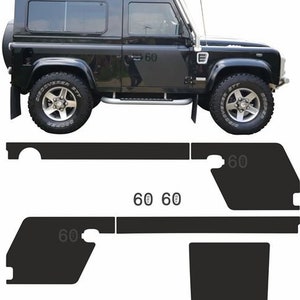 Könnte beinhalten: Schwarzer Land Rover Defender 90 mit schwarzem Dachgepäckträger und schwarzem Trittbrett. Das Fahrzeug hat eine schwarze Stoßstange und schwarze Räder. Das Fahrzeug befindet sich auf einem weißen Hintergrund.