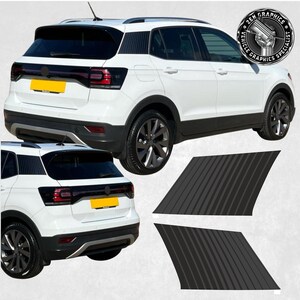 May include: A white Volkswagen T-Roc with black window trim and black side stripes. The car is shown from the rear and side angles. The image also includes two black vinyl decals with vertical stripes.