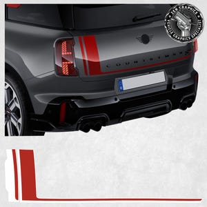 May include: A gray Mini Cooper Countryman with red and white stripes on the back. The car has a black bumper and black exhaust pipes. The car has a license plate that says "D".