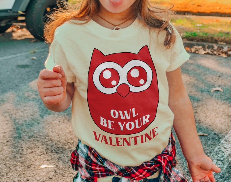 a little girl wearing a owl be your valentine shirt