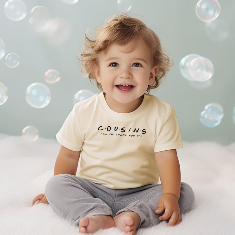 a toddler sitting on a bed with bubbles in the air