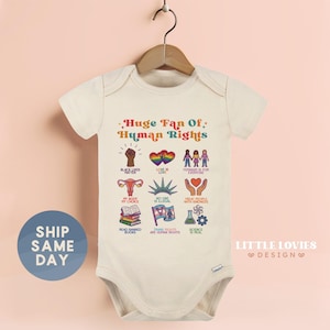 May include: A cream-colored baby bodysuit with the text "Huge Fan Of Human Rights" and various colorful illustrations. The design includes symbols for Black Lives Matter, LGBTQ+ rights, and reproductive rights.
