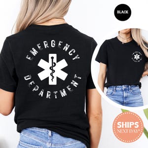 May include: Black t-shirt featuring a white emergency medical services (EMS) star of life symbol with a caduceus in the center. The words "EMERGENCY DEPARTMENT" are printed around the star. A smaller version of the design is on the front.