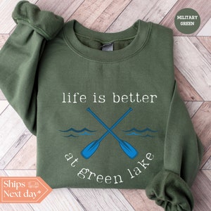a green sweatshirt with two crossed oars and the words life is better at green