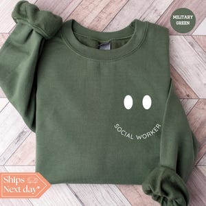 a green sweatshirt with the words social worker on it
